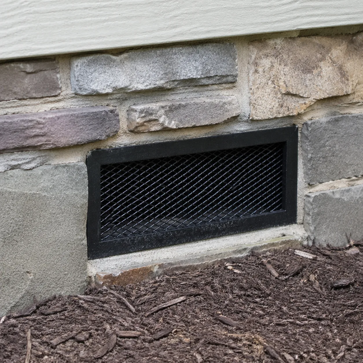 Grille de ventilation d'un vide sanitaire en pied de mur